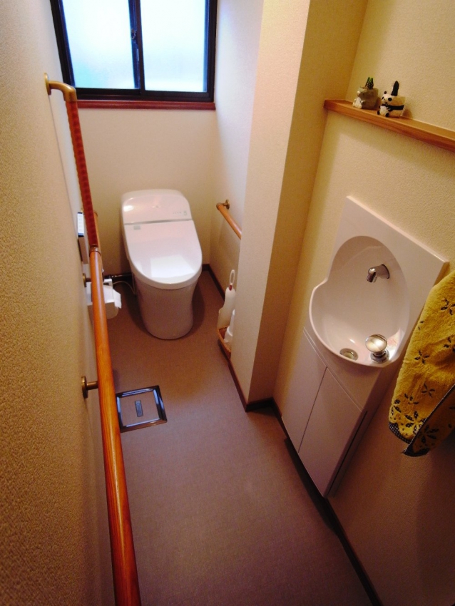 和式トイレから洋式トイレに 小便器のあった場所は埋め込み型の手洗い器を設置。 大便器は奥行の少ない寸法を用いて、中間にある二階排水管の通るパイプスペースの出っ張りを避けています。 
